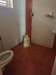 a small bathroom with a toilet and a shower at Raaga on the Beach in Kannur