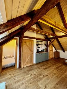 a large room with a bed and wooden ceilings at U nás ve lhotě - apartmány / celá chalupa in Borotín