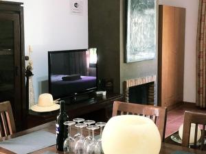 a dining room with a table with wine glasses and a television at Apartamentos Sevilla Deluxe Rosales in Los Rosales
