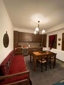 sala de estar con mesa y cocina en La casa Varsani, en Anilio - Metsovo