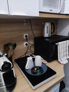 een aanrecht met een koffiezetapparaat en een magnetron bij Garibaldi mini-maison jardin in Saint-Ouen