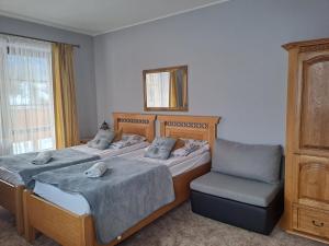 2 camas en una habitación con silla y espejo en Willa Wisienka, en Zakopane