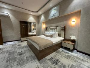 een slaapkamer met een groot bed en een grote spiegel bij Green Park Hotel in Tasjkent