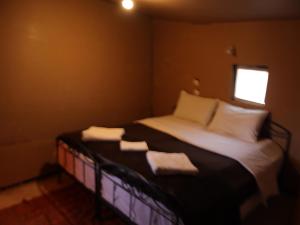 Un pequeño dormitorio con una cama con toallas. en Tamaris Camp en Adrouine