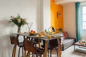 STUDIO VIEUX-PORT VUE BASILIQUE NOTRE-DAME في مارسيليا: غرفة طعام مع طاولة مع فاكهة عليها