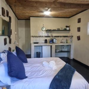 a bedroom with a large white bed with blue pillows at Bedrock Guest Studios in Strand