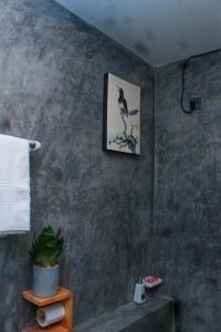 a bathroom with a picture of a bird on the wall at Charming dark lodge in river in Weligama +77 photos