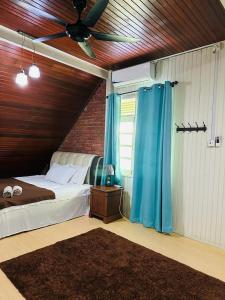 una camera con letto e ventilatore a soffitto di Kak Nor Villa a Kuala Terengganu