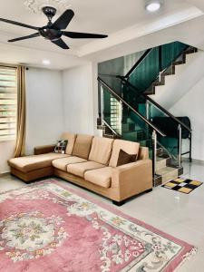 a living room with a couch and a staircase at Kak Nor Villa in Kuala Terengganu
