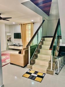 a living room with a staircase and a couch at Kak Nor Villa in Kuala Terengganu