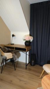 a desk with a vase of flowers on it in a room at Separate floor of a house in Arvidsjaur
