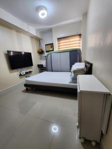 a bedroom with a bed and a tv in it at Budget price condo near IT Park & Ayala, Cebu City in Cebu City