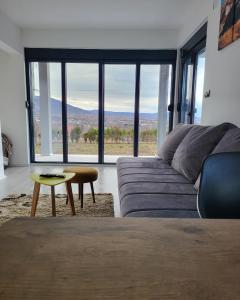 a living room with a couch and a large window at Duos West in Soko Banja