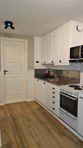 La cuisine est équipée de placards blancs et d'un four avec plaques de cuisson blanches. dans l'établissement Separate floor of a house, à Arvidsjaur