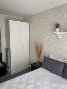 1 dormitorio con 1 cama y armario blanco en At Home Maboneng, en Johannesburgo