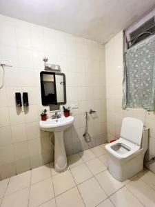 a bathroom with a toilet and a sink and a mirror at Darjeeling Heights - A Boutique Mountain View Homestay in Darjeeling