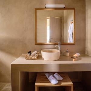a bathroom with a sink and a mirror at Aliter Suites in Fira
