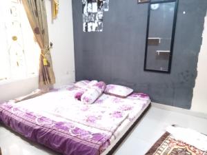 ein Bett mit lila Bettwäsche und Kissen darauf in der Unterkunft Villa ilham in Cibadak