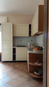 聖費爾迪南多的住宿－PR home，厨房配有白色橱柜和柜台上的一碗水果