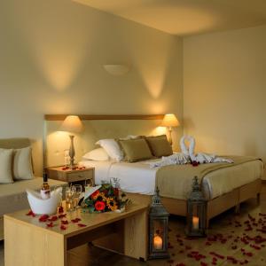 a bedroom with a bed and a table with flowers on it at Aliter Suites in Fira