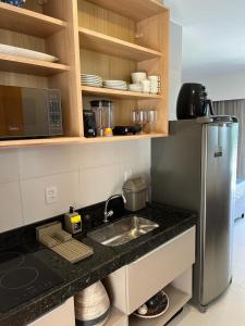 a kitchen with a sink and a refrigerator at Makia beach Experience in Porto De Galinhas
