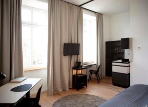 a room with a bed and a table and a kitchen at YokoLou - Design-Apartments in Koblenz