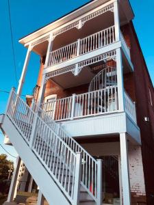 - un bâtiment avec un balcon doté de rails blancs dans l'établissement Church Bells, à Wyalusing