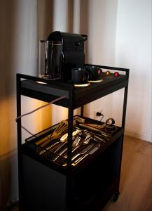 a black cart with pots and pans on it at YokoLou - Design-Apartments in Koblenz