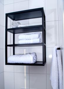 ein schwarzes Regal mit Handtüchern und Handtüchern an einer Wand in der Unterkunft YokoLou - Design-Apartments in Koblenz