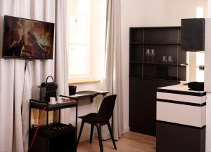 Zimmer mit einem Schreibtisch und einem Tisch mit einem Stuhl in der Unterkunft YokoLou - Design-Apartments in Koblenz