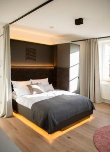 ein Schlafzimmer mit einem großen Bett mit schwarzem Kopfteil in der Unterkunft YokoLou - Design-Apartments in Koblenz