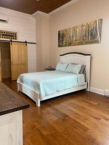 Un dormitorio con una cama y suelo de madera. en Church Bells, en Wyalusing