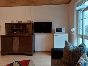 a living room with a tv and a refrigerator at tAllhouse in Eggolsheim