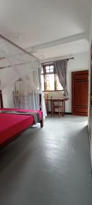 a bedroom with a bed with a mosquito net at Serenity Lodge in Ahangama