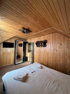 ein Schlafzimmer mit einem großen Bett an einer Holzwand in der Unterkunft Holiday home shale in Bukowel