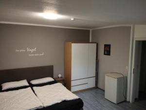 a bedroom with a bed and a white cabinet at Apartmenthaus Wattwurm in Friedrichskoog