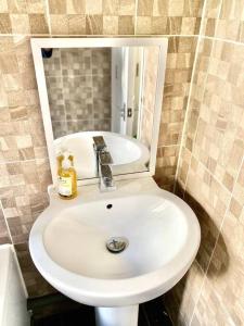 a white sink in a bathroom with a mirror at 1 Bedroom Apartment 3 mins walk Mile End Station in London