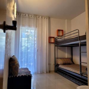 1 dormitorio con 2 literas y ventana en Entre el mar y PortAventura 2, en Salou