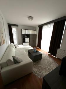 a living room with a white couch and a table at Space Apartments in Raška