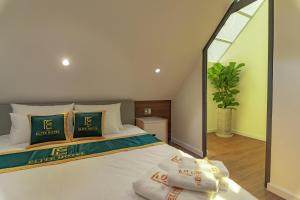 a bedroom with a white bed with a large mirror at THE ELITE HOTEL in Da Lat