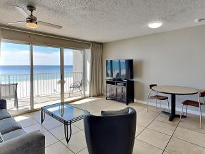 uma sala de estar com um sofá, uma televisão e uma mesa em Long Beach Resort Tower II 305 em Panama City Beach