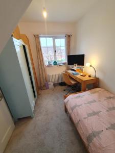 una camera con letto e scrivania con computer di Lotus Pod House Homestay a Horsell