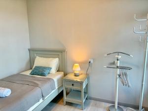 a bedroom with a bed and a table with a lamp at JQ Jesselton Quay Homestay Near Suria Mall, Gaya Street, jetty by GoodTravelKK 善旅民宿 in Kota Kinabalu