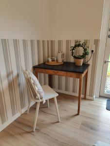 een stoel voor een tafel bij Pension Skovly in Tranekær