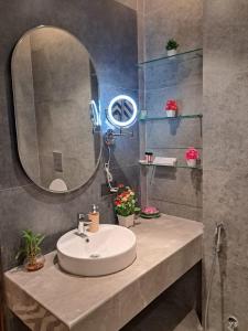 a bathroom with a sink and a mirror at Taj Studios - Luxury Suit at Blue Sapphire Mall #US Cinema #PizzaHut #HIRA Sweets #Food Court etc by GHUMLOO-COM in Ghaziabad