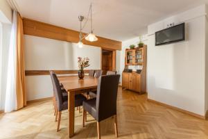 Bella Vista Appartements by Schladming-Appartements في سخلادميخ: غرفة طعام مع طاولة وكراسي خشبية