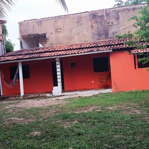 馬拉戈日的住宿－Cantinho da Rosy，一座红色和白色的建筑,有草地庭院