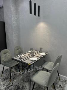 a dining room table with chairs and wine glasses on it at 2-roomed apartment close to REGISTAN Ozod Apartments in Samarkand
