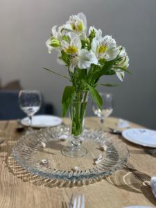 a vase of white flowers sitting on a table at 2-roomed apartment close to REGISTAN Ozod Apartments in Samarkand