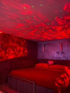 una camera da letto con luci rosse sul soffitto di Sweetlove Spa a Terracina